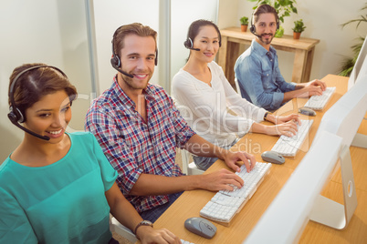 Smiling call centre team looking at the camera