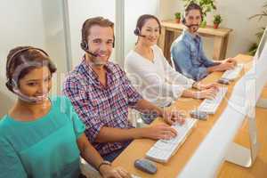 Smiling call centre team looking at the camera