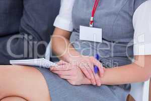 businesswomen taking note during a meeting