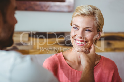 Couple with coffee cup sitting on sofa