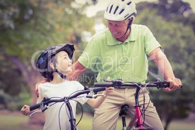 Happy grandfather with his granddaughter on their bike