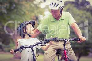 Happy grandfather with his granddaughter on their bike