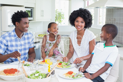 Happy family sitting down to dinner together