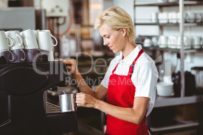 Pretty barista using the coffee machine