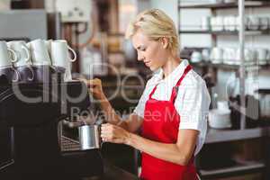 Pretty barista using the coffee machine