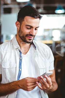 Smiling man on the phone having coffee