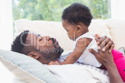 Happy father with baby girl on couch