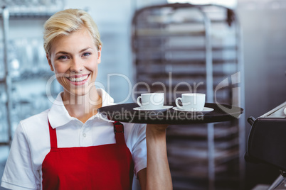 Pretty barista holding two cups of coffee