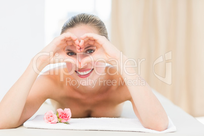 Peaceful blonde lying on towel smiling at camera