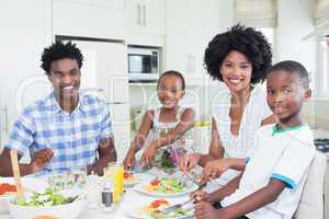 Happy family sitting down to dinner together