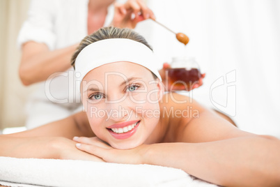 Therapist waxing womans back at spa center