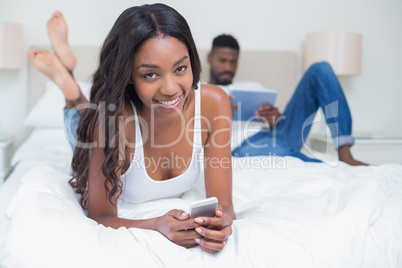 Relaxed couple using technology on bed