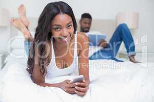 Relaxed couple using technology on bed