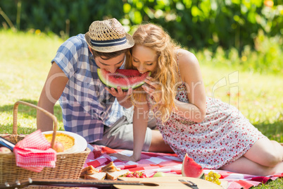 Young couple on a picnic eating watermelon