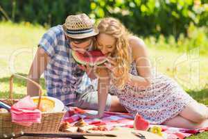 Young couple on a picnic eating watermelon