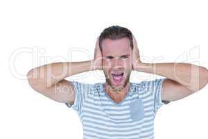 Handsome casual man screaming with hand on ears