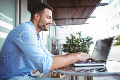 Smiling businessman using his laptop