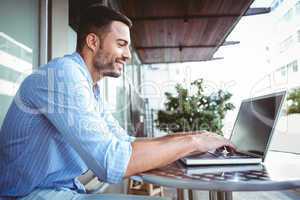 Smiling businessman using his laptop