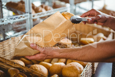 Smiling waiter taking bread with tongs