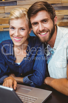 Cute couple on a date watching photos on a laptop