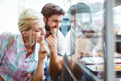 Cute couple on a date looking at cakes