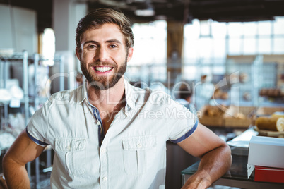 Young man leaning on the counter looking the camera