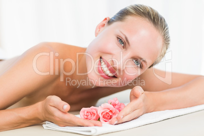 Peaceful blonde lying on towel smiling at camera