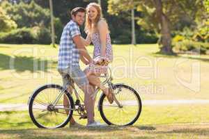 Young couple on a bike ride looking at camera