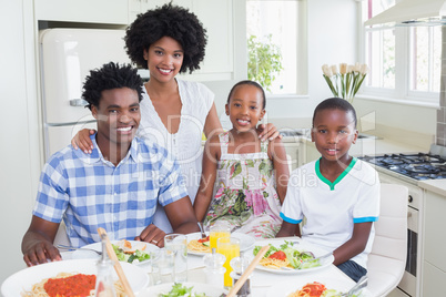 Happy family sitting down to dinner together