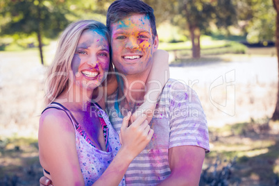 Happy friends covered with powder paint in the park