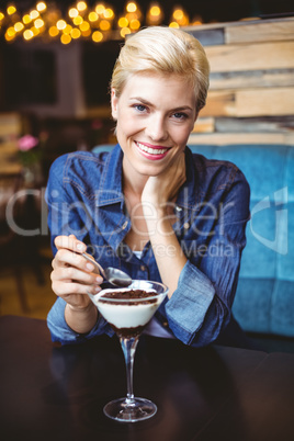 Smiling blonde eating a creamy chocolate