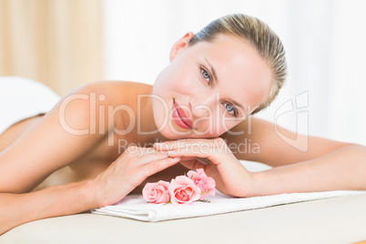 Peaceful blonde lying on towel smiling at camera