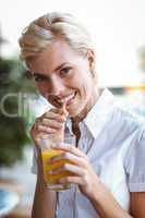 Young woman having glass of orange juice