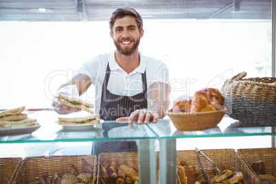 Happy server showing sandwich at camera