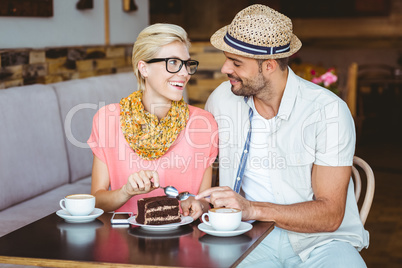 Cute couple on a date eating a piece of chocolate cake