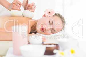 Beautiful blonde enjoying a herbal compress massage