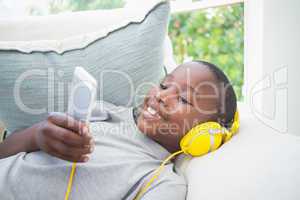 Little boy listening to music on the couch