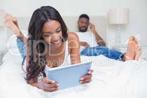 Relaxed couple using technology on bed