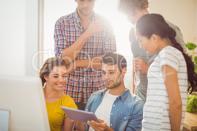 Creative business team gathered around a tablet