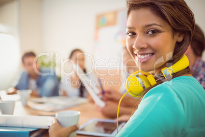 Smiling businesswoman with yellow headphones in a meeting