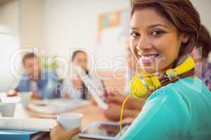 Smiling businesswoman with yellow headphones in a meeting