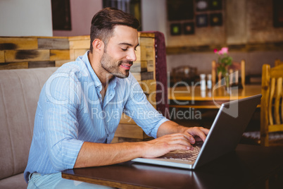 Smiling businessman using his laptop