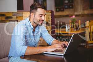 Smiling businessman using his laptop