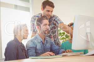 Colleagues using laptop at office