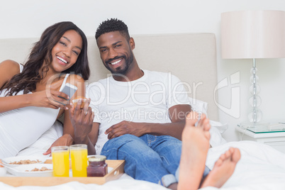 Relaxed couple having breakfast in bed together