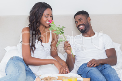 Relaxed couple having breakfast in bed together