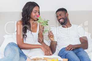 Relaxed couple having breakfast in bed together