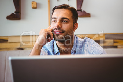 Smiling businessman using his laptop