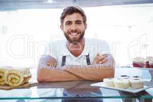 Smiling worker posing behind the counter