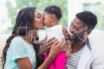 Happy parents with baby girl on couch Happy parents with baby girl on couch